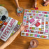 Tipsy Land party board game in play with players holding drinks and cards, colourful adult drinking game for social gatherings and fun nights Adventure Awaits