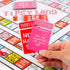 hand holding Tipsy Land game cards over board, including never have I ever and challenge cards, adult party drinking game activity Adventure Awaits