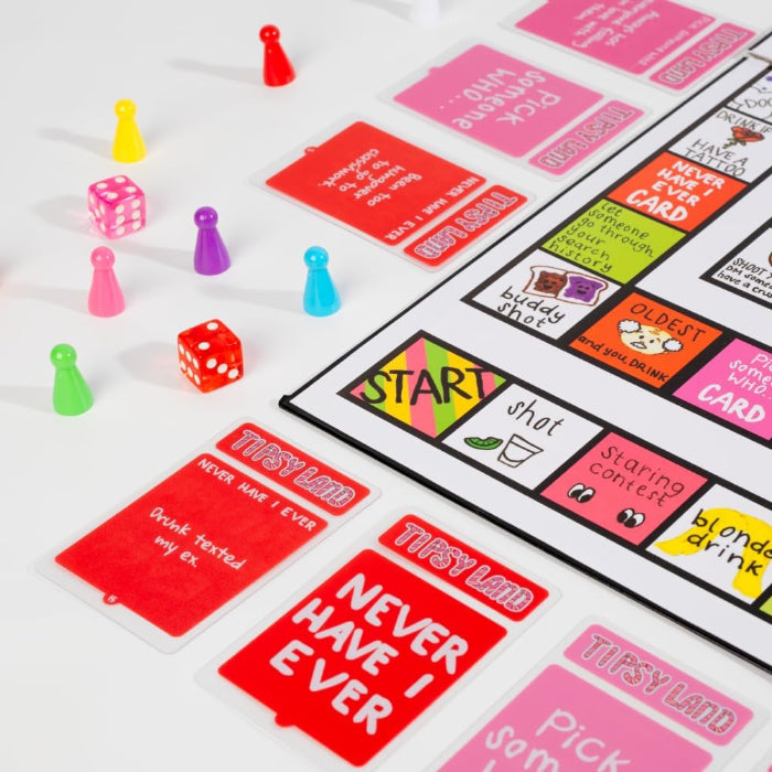 Tipsy Land board game pieces including colourful pawns, dice and cards on game board, fun adult party drinking game setup Adventure Awaits