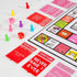 Tipsy Land board game pieces including colourful pawns, dice and cards on game board, fun adult party drinking game setup Adventure Awaits