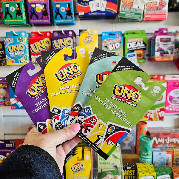 Hand holding colourful UNO Add-On Stack, Swap, Frenemies and Speed Packs in a game shop — Adventure Awaits