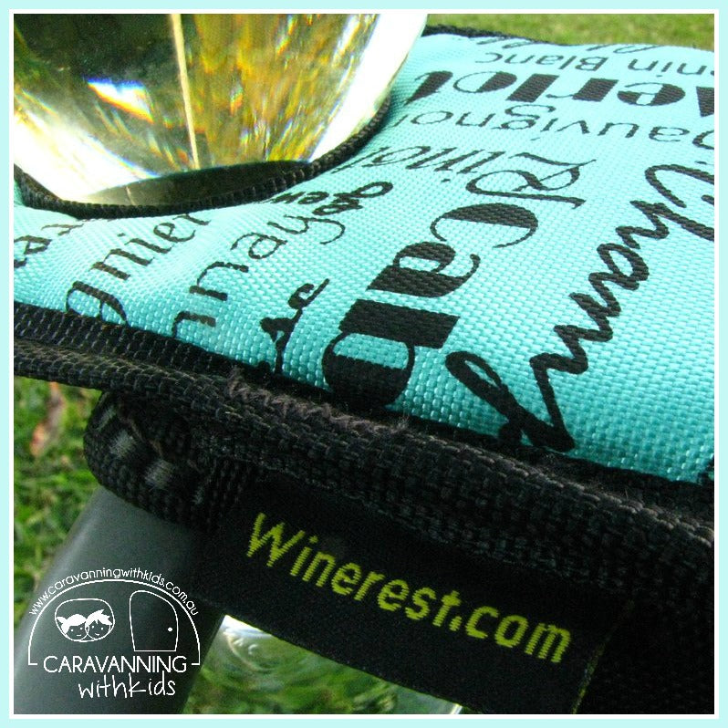 Aqua Winerest padded wine glass holder close up on camp chair arm, sturdy caravanning accessory for outdoor drinks Adventure Awaits