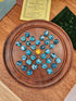 Wooden solitaire board game with blue and silver pieces on a wooden surface