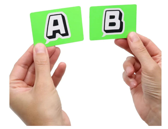 Hands holding green A and B cards from You Can't Say Umm party game — Adventure Awaits