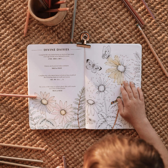 Child completing daisy puzzles and colouring in the Wild Activity Book with pencils — Adventure Awaits