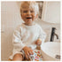 child in bathroom holding animal ouchie pouchie cold pack on knee - Adventure Awaits