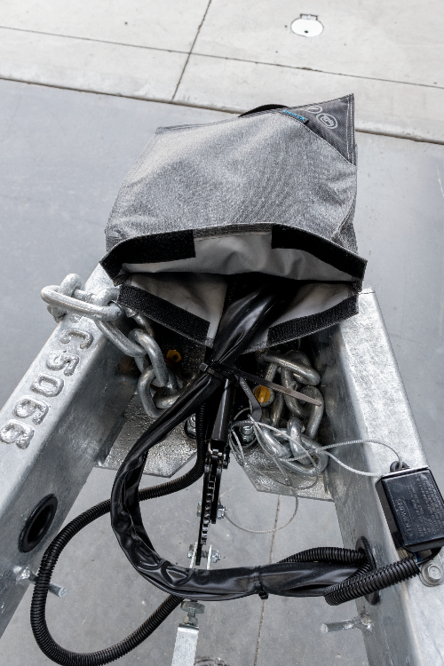 Grey caravan trailer plug cover fitted over chains and trailer wiring — Adventure Awaits