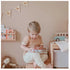Young child using an Ouchie Pouchie cold pack while sitting in a cosy playroom — Adventure Awaits