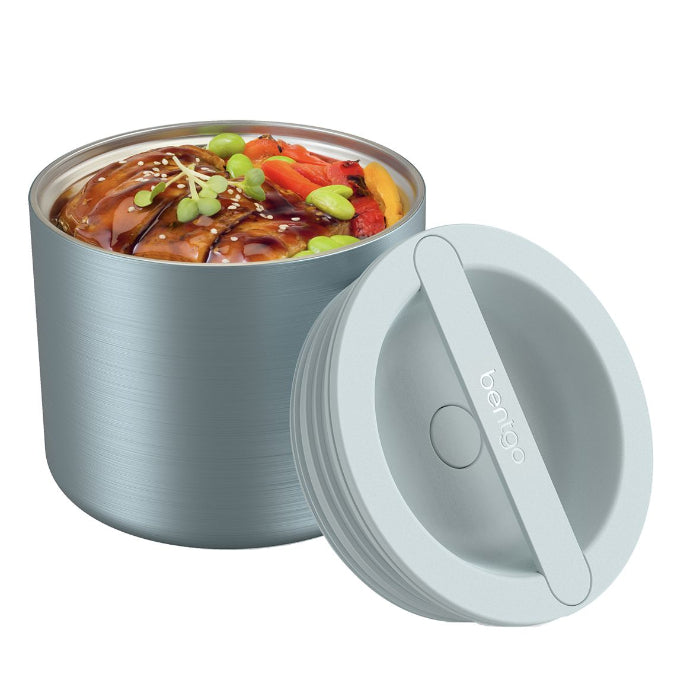 Open blue Bentgo Stainless insulated food container filled with a hot meal beside its lid — Adventure Awaits