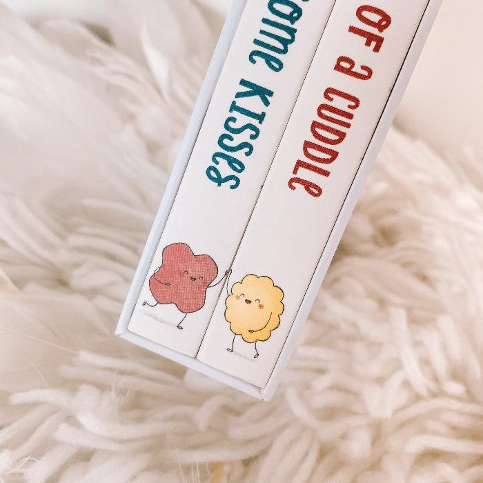 Close-up of board book spines for I Got You Some Kisses and The Gift of a Cuddle — Adventure Awaits