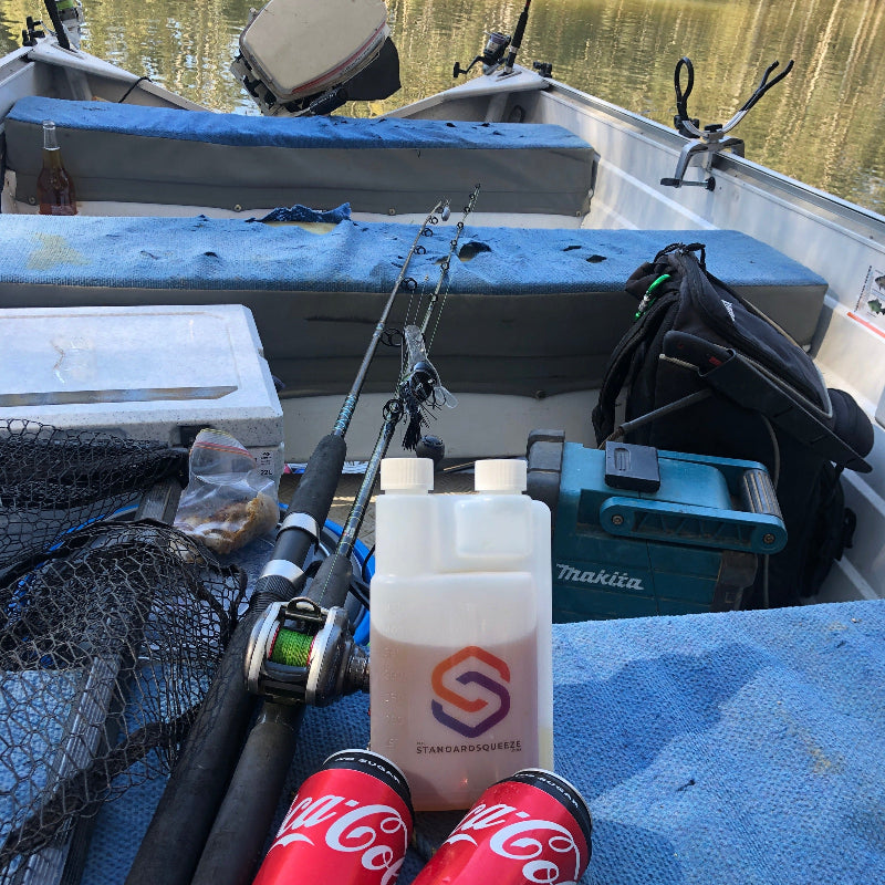 Standard Squeeze Bottle packed with fishing rods and gear on a boat, ready for a day on the water — Adventure Awaits