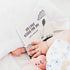 Baby reaching for Ten Little Kisses For You board book in bed — Adventure Awaits