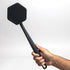 man's hand holding up tooletries back scrubber against white background