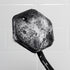 close p of front of tooletries back scrubber covered in suds held up against white shower