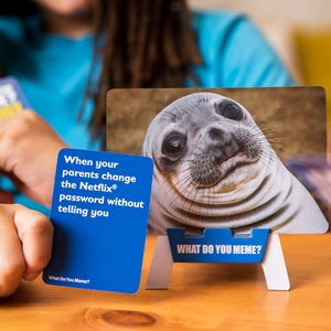 Player matches a blue caption card to a seal photo in What Do You Meme? Family Edition — Adventure Awaits