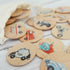 close up of wooden police car memory disc with other transport discs in background on white timber bench